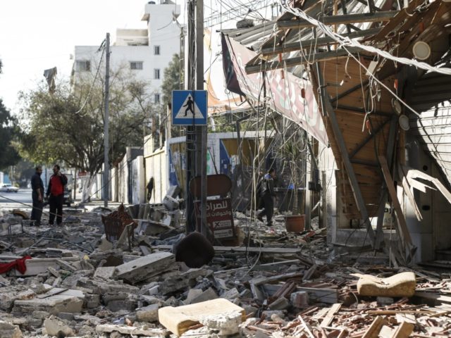 Residents gather in a debris-strewn street in Gaza City on May 5, 2019, that was hit during Israeli air strikes on the Palestinian enclave. - Gaza militants fired fresh rocket barrages at Israel early today in a deadly escalation that has seen Israel respond with waves of strikes as a …