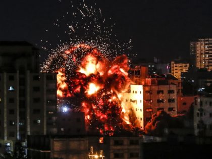 An explosion is pictured among buildings during an Israeli airstike on Gaza City on May 4, 2019. - Gaza militants fired a barrage of rockets at Israel, which responded with airstrikes, officials said, as a fragile ceasefire again faltered. (Photo by Mahmud Hams / AFP) (Photo credit should read MAHMUD …