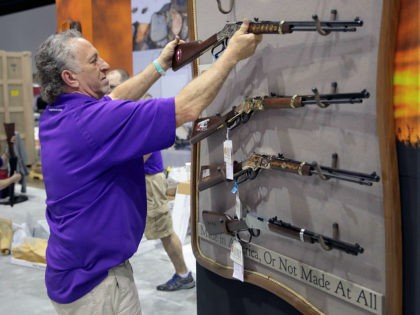 INDIANAPOLIS, INDIANA - APRIL 25: Kevin Berlin helps to prepare the Henry rifle display at