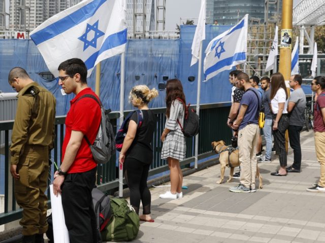 People stop and stand in silence on a street in the Israeli city of Tel Aviv on May 02, 20
