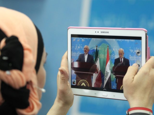 An Iraqi journalist takes a photo of Iranian Foreign Minister Mohammad Javad Zarif (L) dur