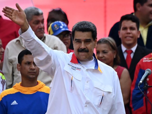 Venezuela's President Nicolas Maduro waves during a rally in front of Miraflores President