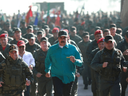 In this photo released to the media by the Miraflores presidential palace press office, Venezuelan President Nicolas Maduro jogs ahead of soldiers during a visit last month to Carabobo State. (Marcelo Garcia/Miraflores presidential palace press office via AP)