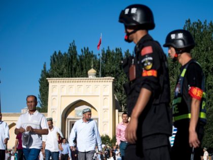 This picture taken on June 26, 2017 shows police patrolling as Muslims leave the Id Kah Mosque after the morning prayer on Eid al-Fitr in the old town of Kashgar in China's Xinjiang Uighur Autonomous Region. The increasingly strict curbs imposed on the mostly Muslim Uighur population have stifled life …