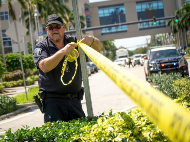 HOLLYWOOD, FL - SEPTEMBER 13: A Hollywood Police Department officer wraps crime scene tape