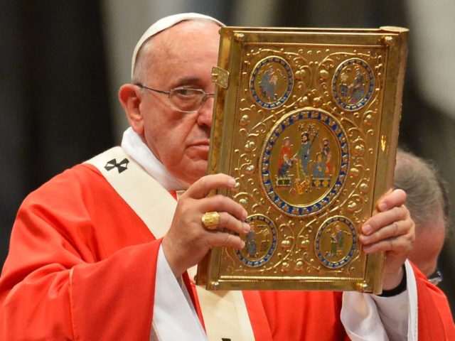 Pope Francis holds aloft the book of the gospels as he leads a mass for the imposition of the Pallium upon the new metropolitan archbishops and the solemnity of Saints Peter and Paul on June 29, 2014 at St Peter's basilica in Vatican. AFP PHOTO / VINCENZO PINTO (Photo credit …