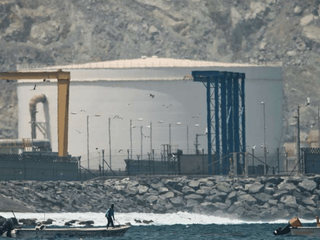 fisherman prepares his boat near an oil storage tank in Fujairah, United Arab Emirates, Mo