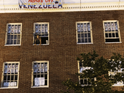 An activist who supports Venezuelan Nicolas Maduro stands by the window of the Venezuelan Embassy in Washington, Monday, May 13, 2019. U.S. authorities have served an eviction notice to activists who have stayed for more than a month inside the embassy and asked them to leave immediately. (AP Photo/Luis Alonso …