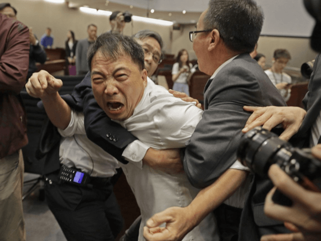 Pro-democracy lawmaker Wu Chi-wai, center, scuffles with security guards at Legislative Co