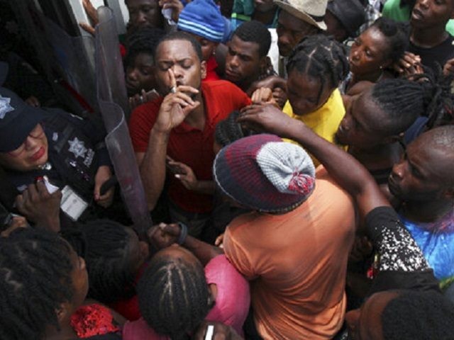 Haitian migrants scuffle at the door of an immigration center for a space in line for a turn to solve their migratory situation, in Tapachula, Chiapas state, Mexico, Monday, May 27, 2019. The Mexican government is trying to encourage more migrants to regularize their status and stay in the south, …
