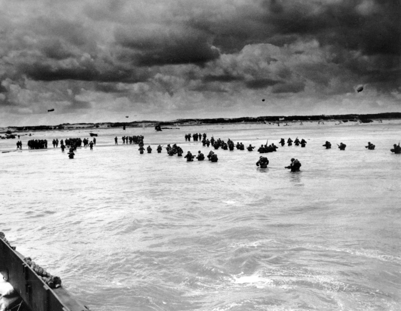 FILE - In this June 1944, file photo, U.S. reinforcements wade through the surf as they land at Normandy in the days following the Allies', D-Day invasion of occupied France. June 6, 2019, marks the 75th anniversary of D-Day, the assault that began the liberation of France and Europe from German occupation, leading to the end World War II. (U.S. Coast Guard via AP, File)