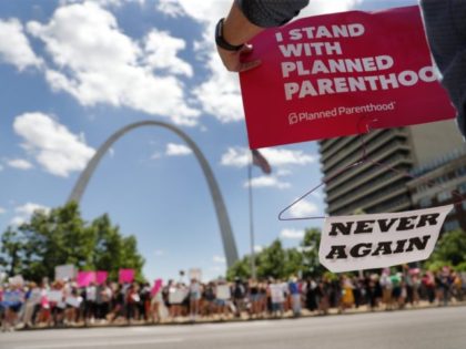 Abortion-rights supporters stand on both sides of a street near the Gateway Arch as they take part in a protest in favor of reproductive rights Thursday, May 30, 2019, in St. Louis. A St. Louis judge heard an hour of arguments Thursday on Planned Parenthood's request for a temporary restraining …