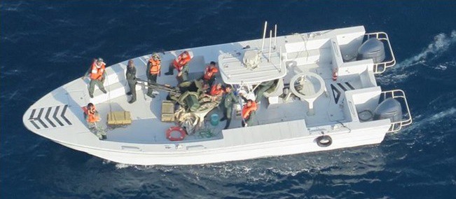 This image released by the U.S. Department of Defense on Monday, June 17, 2019, and taken from a U.S. Navy helicopter, shows what the Navy says is the Islamic Revolutionary Guard Corps Navy after removing an unexploded limpet mine from the M/T Kokuka Courageous. (U.S. Department of Defense via AP)