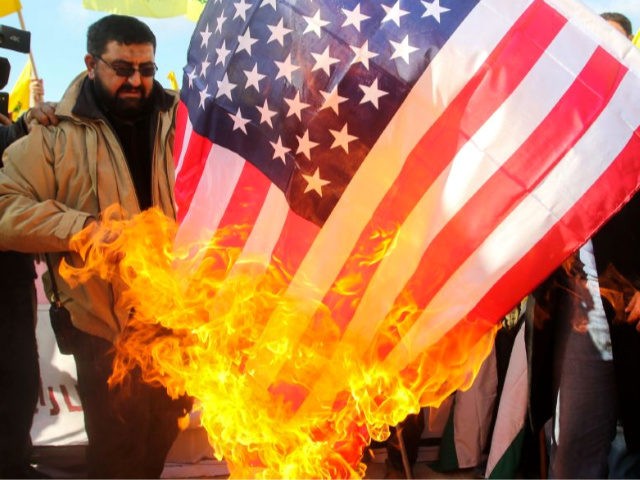 Lebanese supporters of the Shiite Hezbollah movement burn a US flag during a rally against