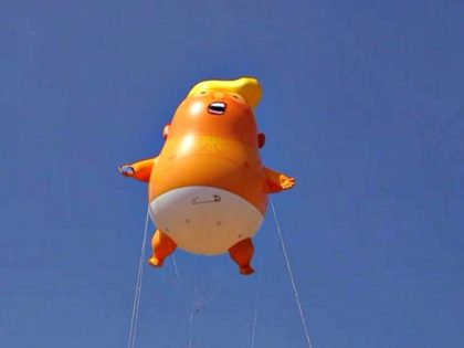 A six-meter high cartoon baby blimp of U.S. President Donald Trump is flown as a protest against his visit, in Parliament Square backdropped by the scaffolded Houses of Parliament and Big Ben in London, July 13, 2018. (Matt Dunham/AP)