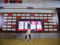 A woman looks at goods on an electronic screen at a T-Mall exhibition during the Singles Day shopping festival in Shanghai on November 11, 2017. - China's smartphone-wielding masses unleashed billions of dollars in e-commerce spending November 11 as they rushed to snap up bargains on "Singles Day" -- billed …