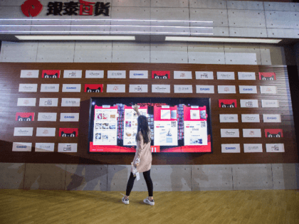 A woman looks at goods on an electronic screen at a T-Mall exhibition during the Singles D