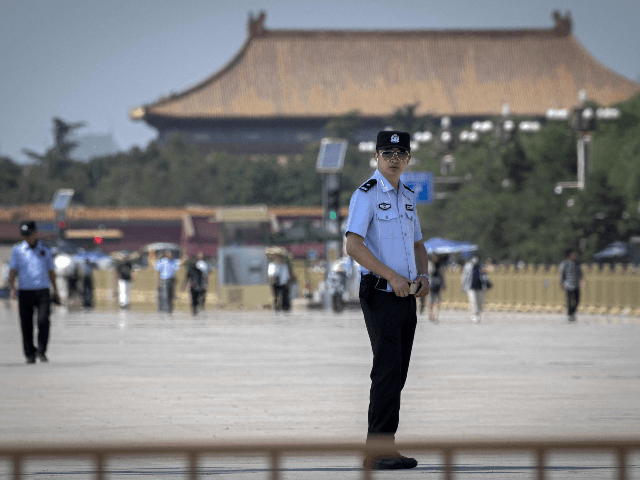 Police officers (L and front) secure Tiananmen Square in Beijing on June 3, 2019. - China