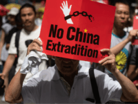 TOPSHOT - A protester marches with a placard during a rally against a controversial extradition law proposal in Hong Kong on June 9, 2019. - Huge protest crowds thronged Hong Kong on June 9 as anger swells over plans to allow extraditions to China, a proposal that has sparked the …