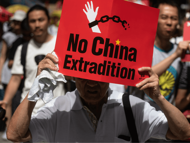 TOPSHOT - A protester marches with a placard during a rally against a controversial extrad