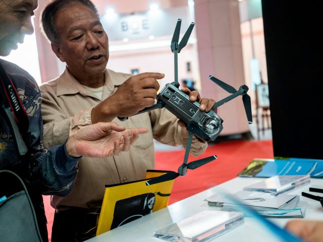 Visitors look at a drone from the Chinese company DJI at the Beijing Photo fair on May 4,