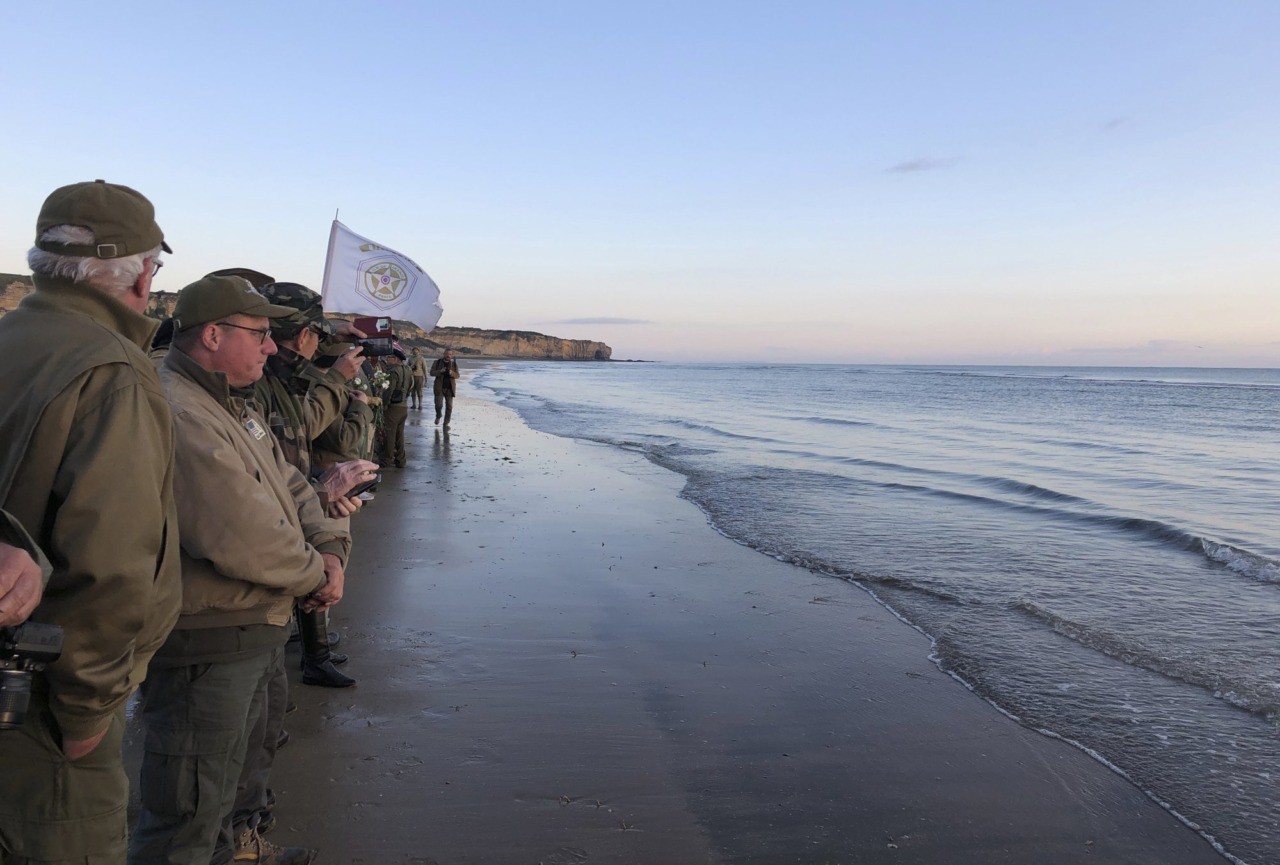 Re-enactors stand at the shore of Omaha Beach at sunrise as part of events to mark the 75th anniversary of D-Day on Omaha Beach in Vierville-sur-Mer, Normandy, France, Thursday, June 6, 2019. World leaders are gathered Thursday in France to mark the 75th anniversary of the D-Day landings. (Cedric Lecoz via AP)