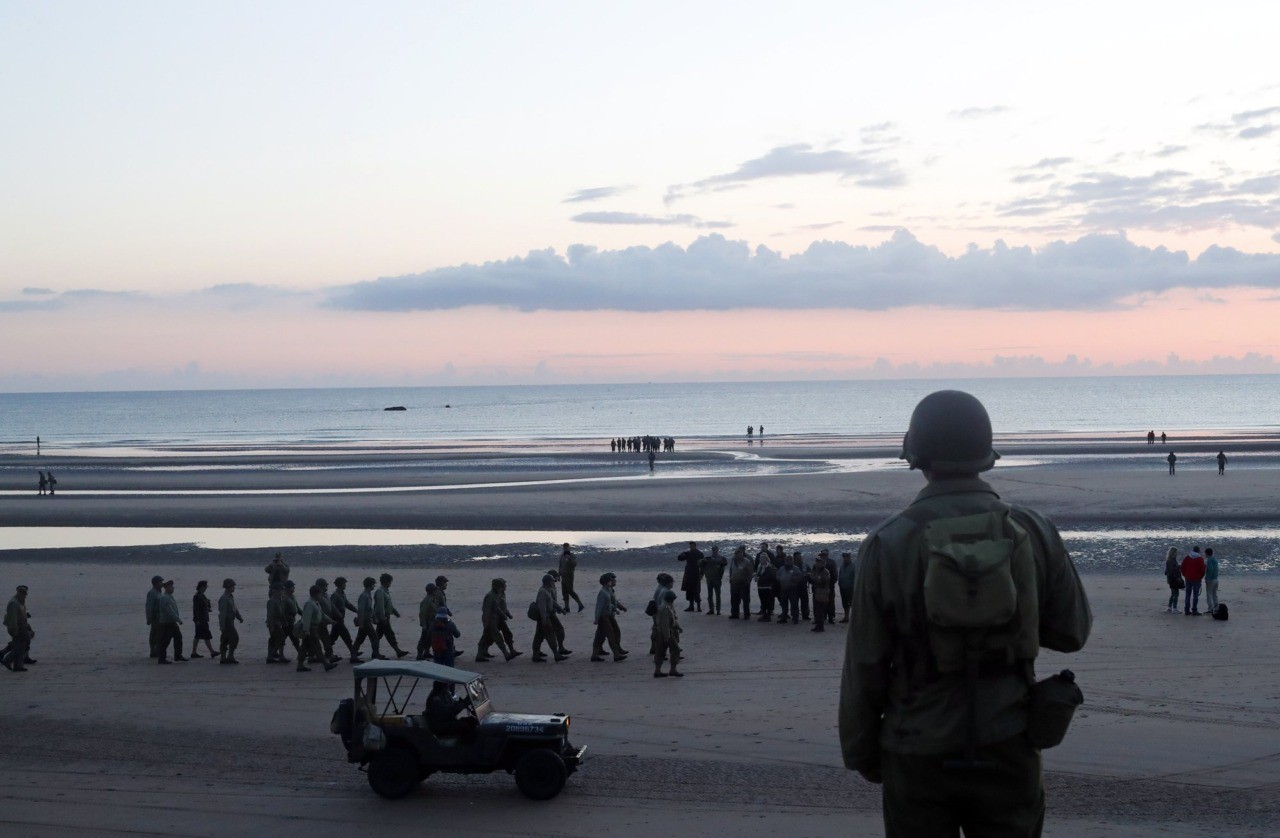 A World War II reenactor looks out over Omaha Beach, in Normandy, France, at dawn on Thursday, June 6, 2019 during commemorations of the 75th anniversary of D-Day. (AP Photo/Thibault Camus)