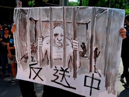 A protester displays a painting during a demonstration in Taipei on June 16, 2019, in support of the continuing protests taking place in Hong Kong against a controversial extradition law proposal. - Tens of thousands of people rallied in central Hong Kong on Sunday as public anger seethed following unprecedented …
