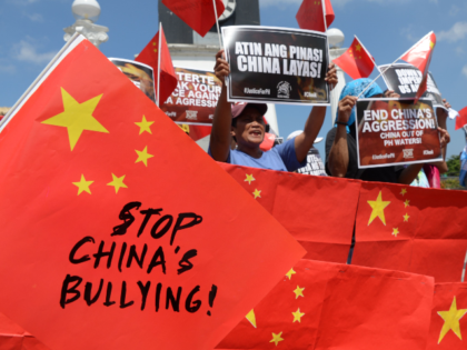 Activists display anti-China placards and flags during a protest at a park in Manila on Ju