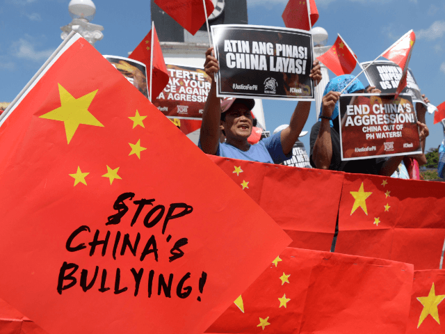 Activists display anti-China placards and flags during a protest at a park in Manila on Ju