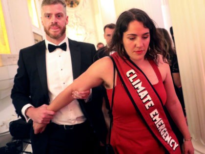 LONDON, ENGLAND - JUNE 20: Climate change protester is escorted out after interrupting British Chancellor of the Exchequer Philip Hammond's speech during the annual Mansion House dinner on June 20, 2019, in London, England. Greenpeace volunteers wearing red evening dress with sashes reading "climate emergency" gatecrashed and disrupted the beginning …