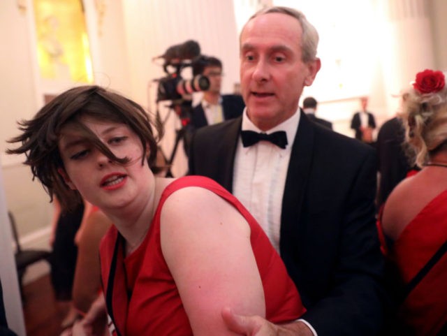 LONDON, ENGLAND - JUNE 20: A climate change protester is escorted out after interrupting a speech during the annual Mansion House dinner on June 20, 2019, in London, England. Greenpeace volunteers wearing red evening dress with sashes reading "climate emergency" gatecrashed and disrupted the beginning of Chancellor Philip Hammond's Mansion …