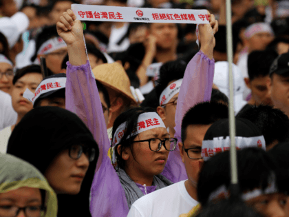 Thousands of protesters hold placards with messages "reject red media and safe guard the nation's democracy" during a rally on Ketagalan Boulevard in front of the presidential office building in Taipei on June 23, 2019. - A rally against pro-Beijing Taiwanese media was held, with tens of hundreds of people …