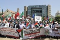 Palestinians hold up placards outside the United Nations headquarters in Beirut to protest against a US-sponsored Middle East economic conference in Bahrain on June 25, 2019. - US President Donald Trump's administration organised the conference, which is to be held on June 25 and 26 in Manama for the unveiling …