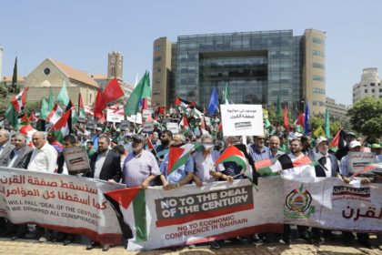 Palestinians hold up placards outside the United Nations headquarters in Beirut to protest
