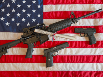 This February 4, 2013 photo illustration in Manassas, Virginia, shows a Colt AR-15 semi-automatic rifle a Colt .45 semi-auto handgun and a Walther PK380 semi-auto handgun and a copy of the US Constitution on top of the American flag. US President Barack Obama Monday heaped pressure on Congress for action …