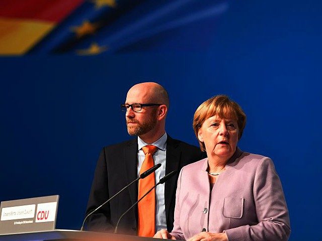 German Chancellor Angela Merkel(R) speaks with journalists next to CDU secretary general P