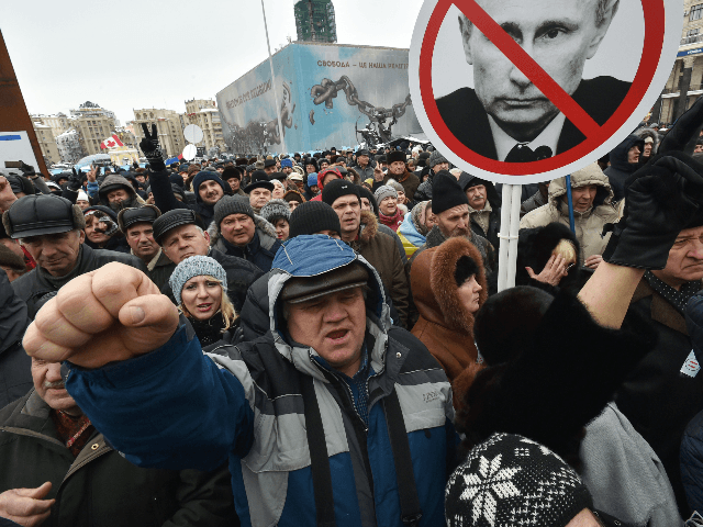 Activists hold placards depicting Russian President Vladimir Putin during a rally calling