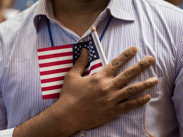 NEW YORK, NY - JULY 3: A new U.S. citizen holds a flag to his chest during the Pledge of Allegiance during a naturalization ceremony at the New York Public Library, July 3, 2018 in New York City. 200 immigrants from 50 countries became citizens during the ceremony, one day …