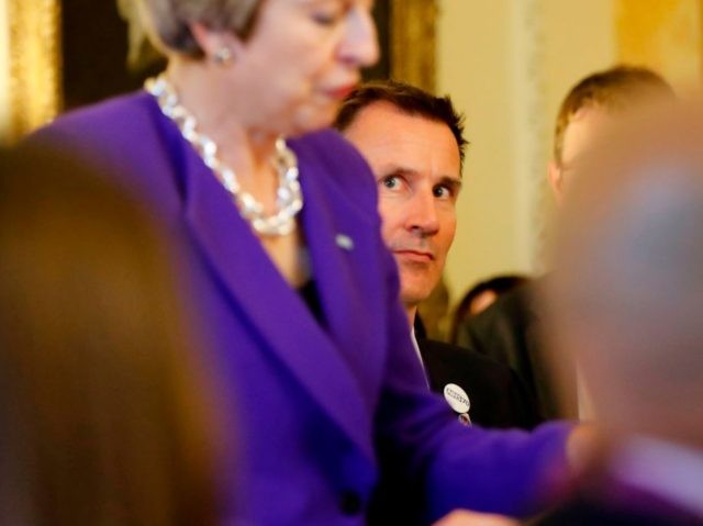 Britain's Health Secretary Jeremy Hunt (R) looks on as Britain's Prime Minister