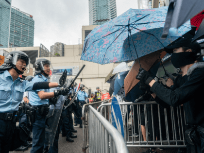 Police officers stand guard as protesters block a street near the government headquarters