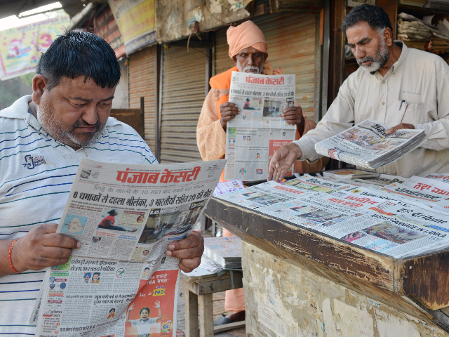 Indian men read newspapers displaying front page news on the Easter Sunday bombings in Sri