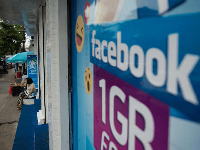 The Facebook logo is seen on an advertisement by a local telecom company in Yangon on June 7, 2018. - Facebook has blacklisted a group of Myanmar Buddhist hardliners including monks notorious for bilious hate speech against Rohingya Muslims, the company said June 7, as it scrambles to show it …