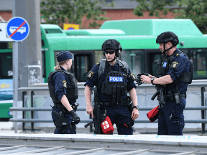 Policemen stand guard outside the central train station after a man threatened to detonate a bomb in Malmö in southern Sweden on June 10, 2019. - The station building was evacuated due to alarms about a suspected object. The man was wounded by police and his bag destroyed by deminers. …