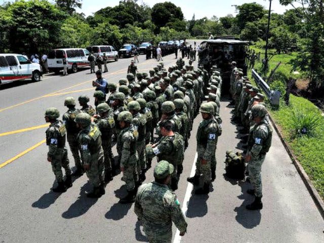Military Police form up on the highway, in Metapa, Chiapas state Mexico, Wednesday, June 5, 2019. A law enforcement group of police officers, Marines, Military Police and immigration officials arrived at the area to intercept a caravan of migrants that had earlier crossed the Mexico – Guatemala border. (AP Photo/Marco …