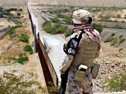 A member of Mexican National Guard watches the border with the US at the Anapra area in Ciudad Juarez, State of Chihuahua, Mexico, on June 26, 2019. - Mexico's president vowed Tuesday to investigate the controversial detention of migrants trying to cross the US border, saying the 15,000 troops he …