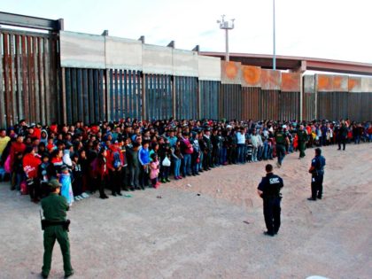 This May 29, 2019 photo released by U.S. Customs and Border Protection (CBP) shows some of 1,036 migrants who crossed the U.S.-Mexico border in El Paso, Texas, the largest that the Border Patrol says it has ever encountered. Video shows them going under a chain-link fence to the U.S., where …