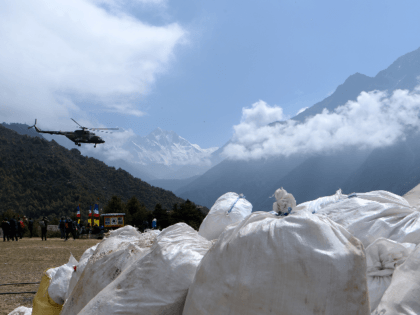 A Nepali Army helicopter flies over waste collected from Mount Everest at Namche Bazar in Solukhumbu district on May 27, 2019, before it is transported to Kathmandu to be recycled. - Some ten tonnes of garbage have been picked from Mount Everest and four bodies retrieved at the end of …