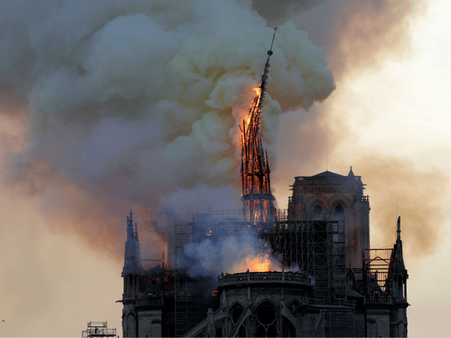 TOPSHOT - The steeple and spire of the landmark Notre-Dame Cathedral collapses as the cath
