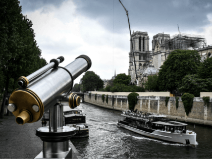 A fly boat cruises along the River Seine past the Notre-Dame de Paris Cathedral, which was badly damaged by a huge fire on April 15, and which is under repair, on May 20, 2019, in the French capital Paris . (Photo by STEPHANE DE SAKUTIN / AFP) (Photo credit should …